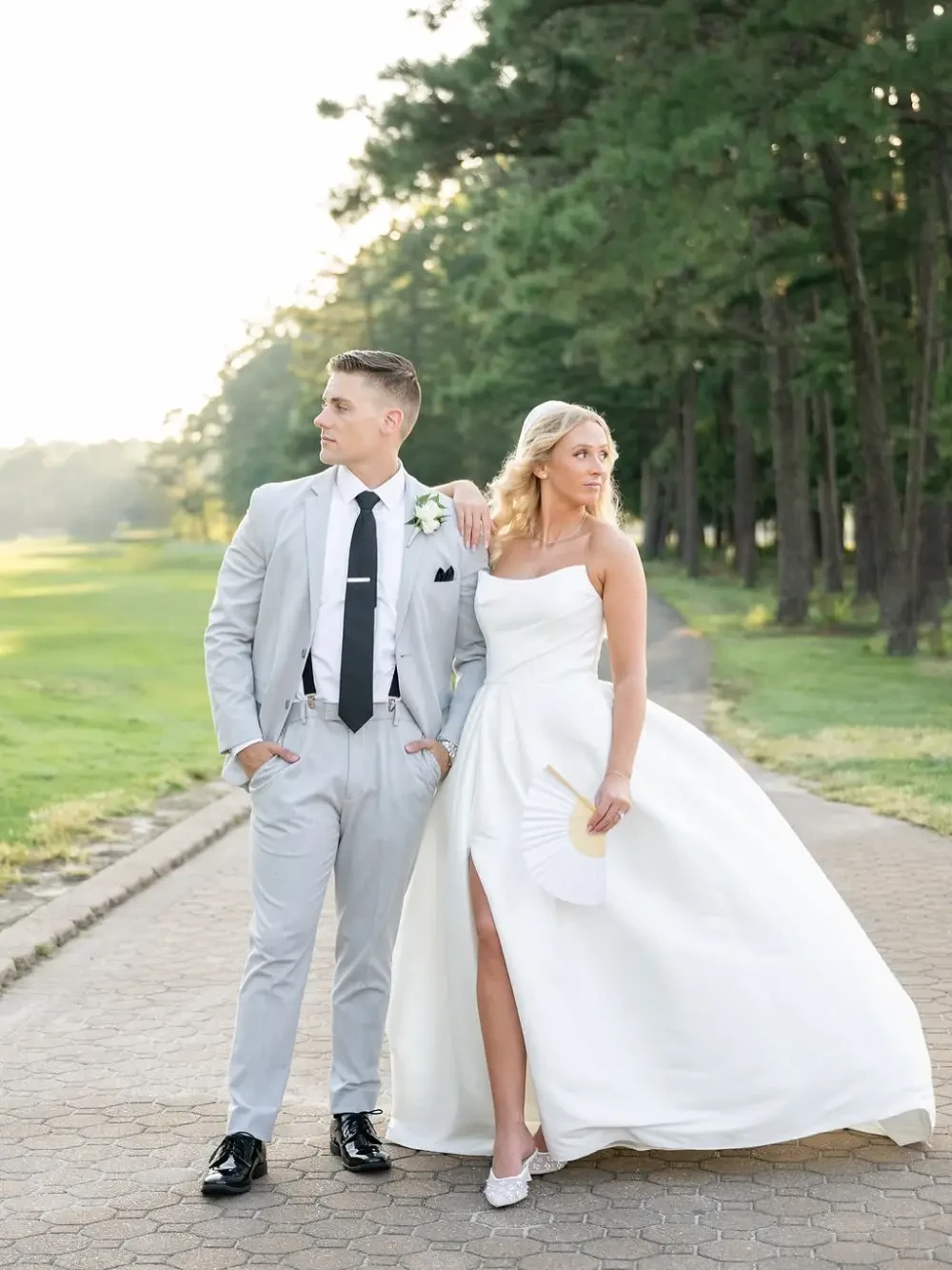 Сouple wearing a white gown and a black suit at home