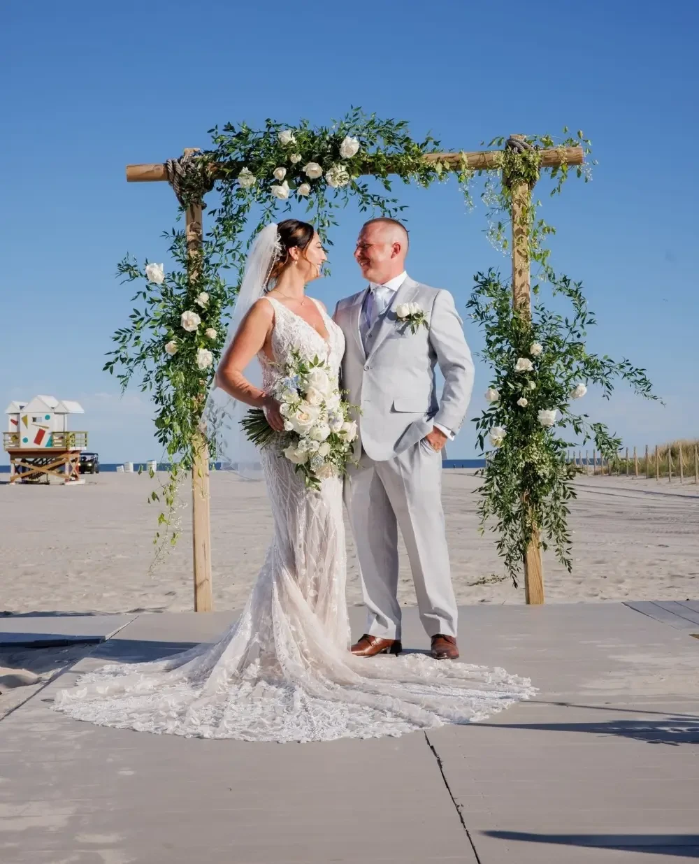 Сouple wearing a white gown and a black suit at home