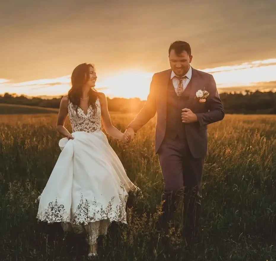Сouple wearing a white gown and a black suit at home